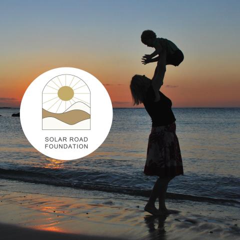 mother and child on beach, solar road foundation logo