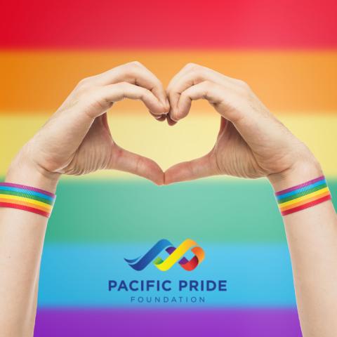 pride flag background with hands forming a heart