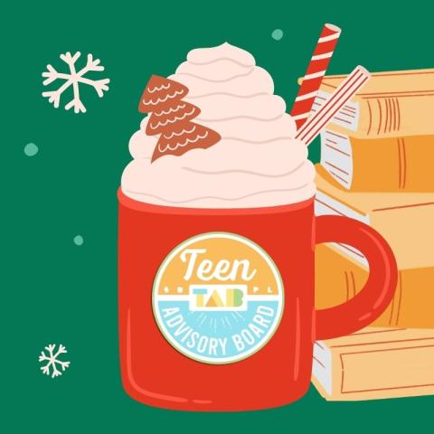 Red mug topped with whipped cream with the T.A.B. logo next to a stack of books on a evergreen background.