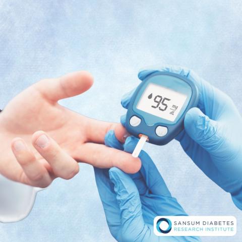 Photograph of a glucose meter performing a finger prick, featuring a Sansum Diabetes Research Institute logo in the corner.