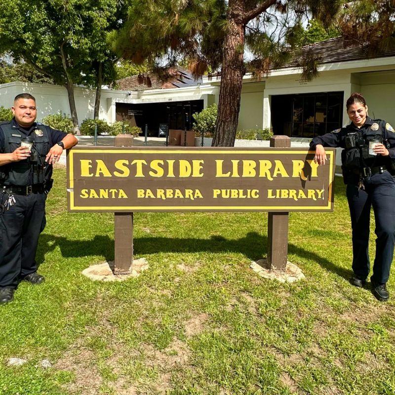 Photo of two SBPD officers posing with the Eastside Library sign.